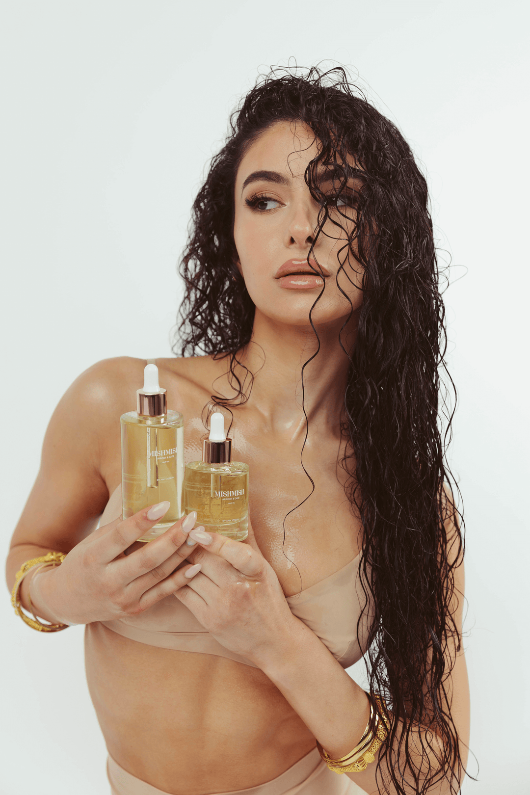 MishMish Brands founder Amy Joseph holding the two sizes of her hair oil